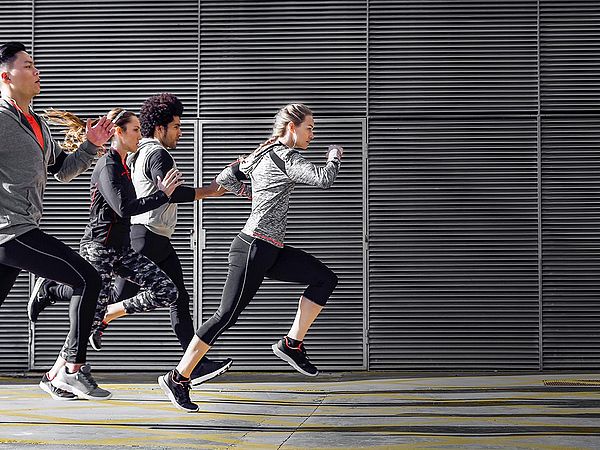 Eine Gruppe von Sportlerinnen und Sportlern joggen gemeinsam in der Stadt