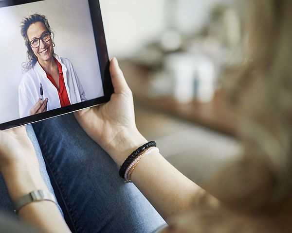 Eine Patientin wird per Video auf ihrem Tablet von einer Ärztin beraten.