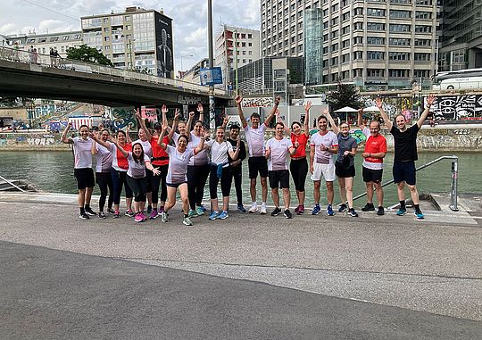 Mitarbeiterinnen und Mitarbeiter stehen bei einem gemeinsamen Lauftreff für ein Gruppenfoto beisammen.