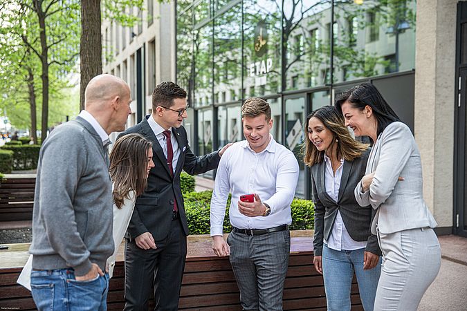 Eine Gruppe von Personen steht beisammen und unterhält sich.