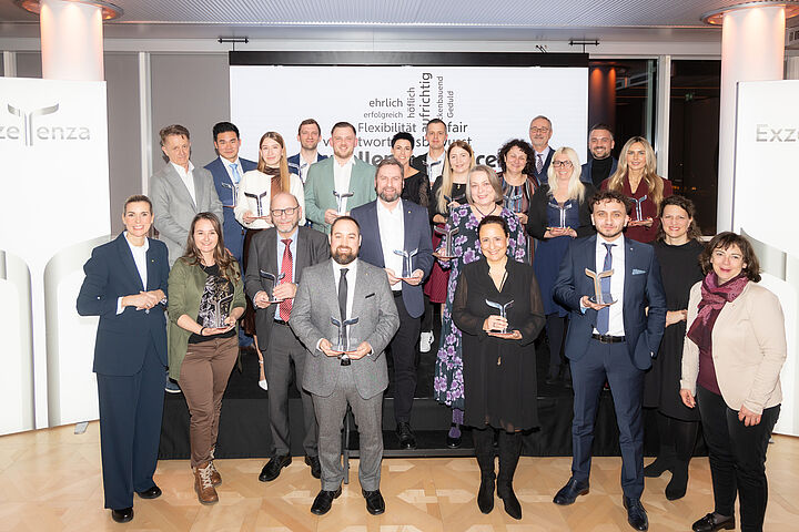 Gruppenfoto bei der Exzellenza-Verleihung mit Glastrophäen.