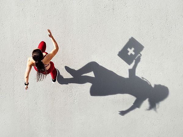 Frau läuft von oben fotografiert mit langem Schatten.