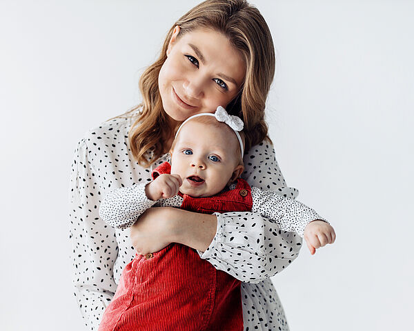 Eine glückliche Frau hält ihre junge Tochter in den Armen