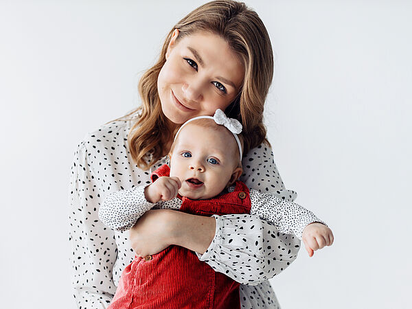 Eine glückliche Frau hält ihre junge Tochter in den Armen