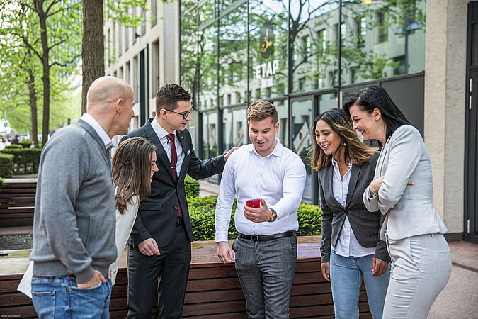 Eine Gruppe von Personen steht beisammen und unterhält sich.