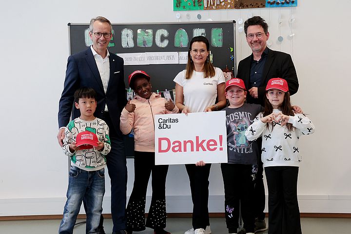 Auf dem Bild sieht man 3 Erwachsene und 4 Kinder mit Danke-Schild