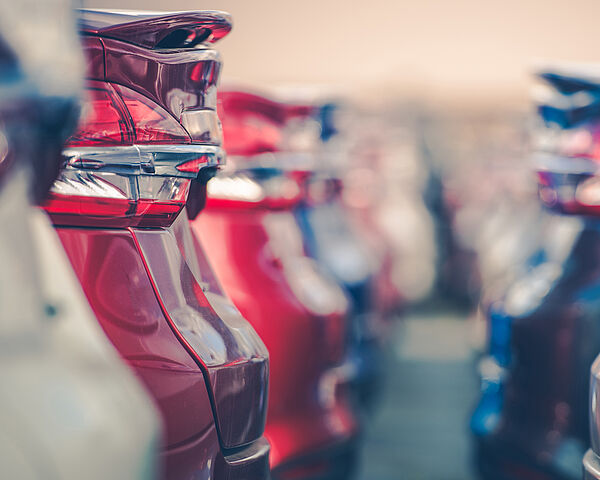 Eine Aneinanderreihung von parkenden Autos. Zwei Reihen von Autos stehen sich jeweils mit der Hinterseite gegenüber.