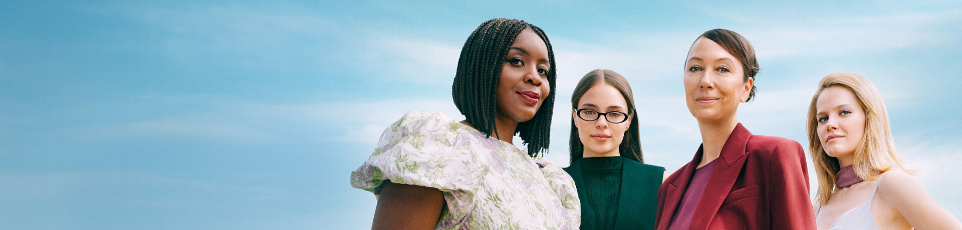 Vier Frauen stehen selbstbewusst nebeneinander vor einem hellblauen Himmel. Links im Bild ist der Schriftzug „#frausorgtvor“ sowie ein kurzer Text zur selbstbestimmten und flexiblen Vorsorge zu sehen, daneben ein Button mit der Aufschrift „Jetzt vorsorgen“. Die Szene vermittelt Stärke, Vielfalt und Zusammenhalt.