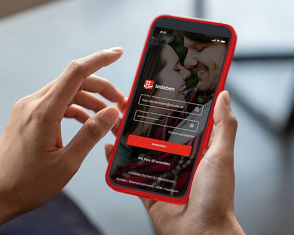 Ein Smartphone wird während der Anmeldung in der losleben-App in den Händen gehalten.