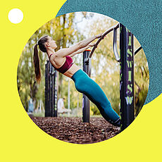 Eine sportliche Frau mit Pferdeschwanz führt in einem Outdoor-Fitnesspark eine Schrägliegestütz-Übung an einer Metallstange aus.