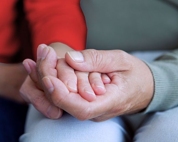 Ein Seniorenpaar hält Händchen. 