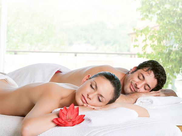 Ein junges Paar liegt entspannt nach einer SPA Behandlung auf Massageliegen 