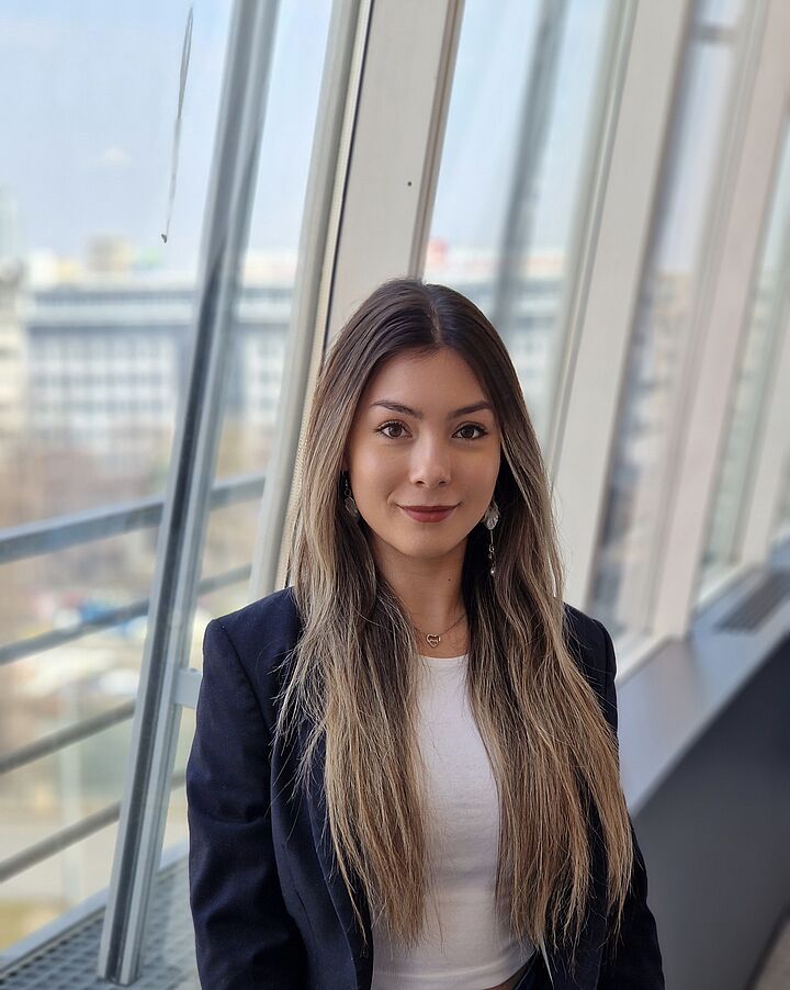 Eine Mitarbeiterin in einem Blazer steht im Gang des Ringturms.