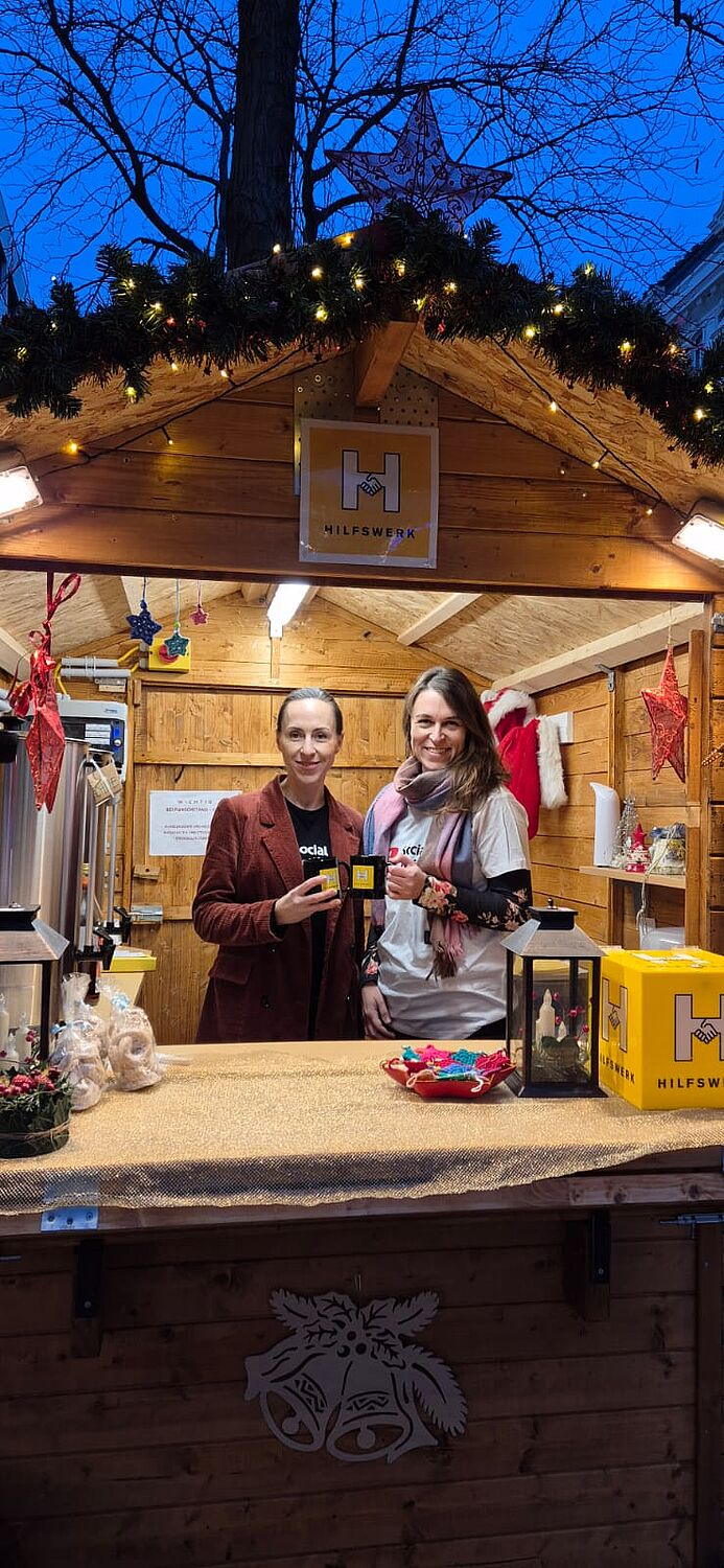 Auf dem Bild sieht man 2 Frauen in einem Punschstand