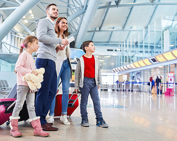 Eine junge Familie wartet am Flughafen auf ihren Abflug.