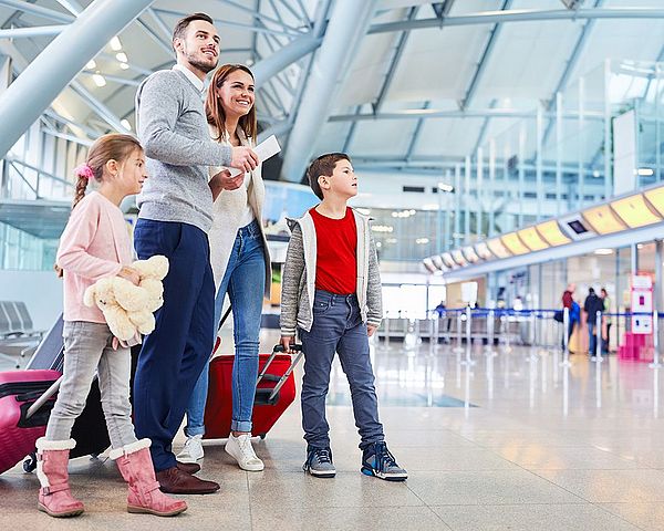 Eine junge Familie wartet am Flughafen auf ihren Abflug.
