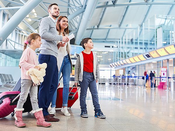 Eine junge Familie wartet am Flughafen auf ihren Abflug.