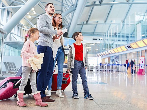 Eine junge Familie wartet am Flughafen auf ihren Abflug.