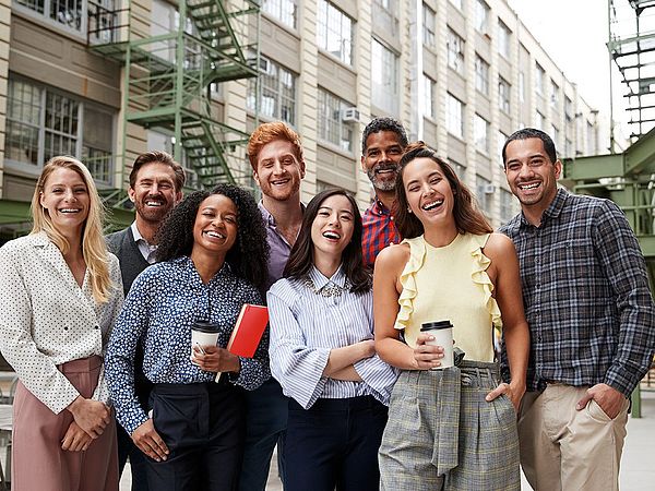 Acht glückliche junge Menschen machen ein Gruppenfoto.