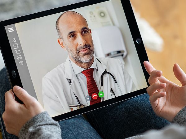 Eine Frau wird per Videoanruf auf ihrem Tablet von einem Arzt beraten.