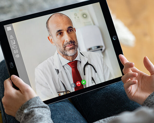 Eine Frau wird per Videoanruf auf ihrem Tablet von einem Arzt beraten.