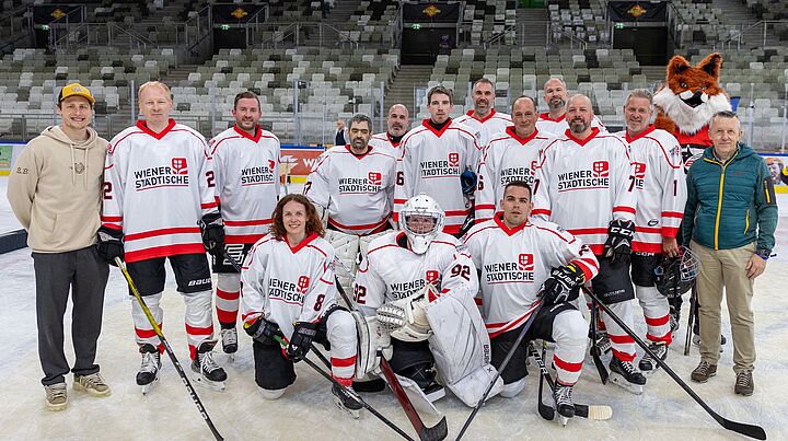Gruppenfoto einer Eishockeymannschaft auf dem Spielfeld.