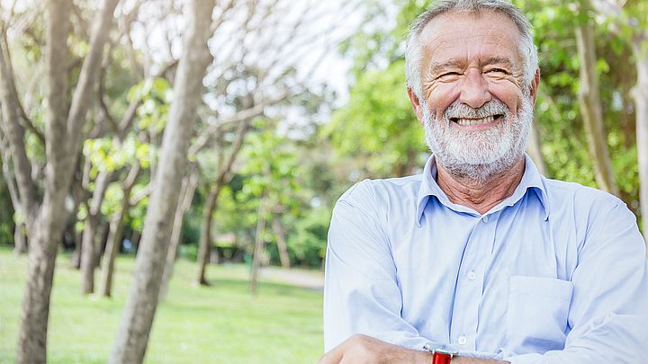 Porträt eines glücklichen Pensionisten in einem Park.