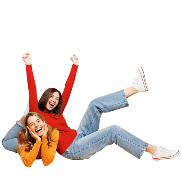 Blonde und dunkelhaarige Frau liegen lachend am Boden und lächeln.