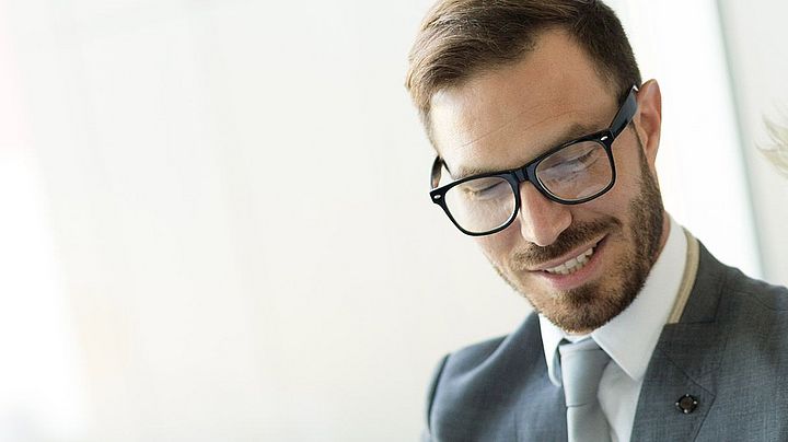 Eine Frau und ein Mann im Anzug besprechen etwas im Büro.