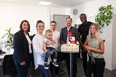 Mehrere Personen blicken in die Kamera und lächeln.