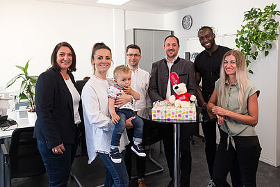 Mehrere Personen blicken in die Kamera und lächeln.