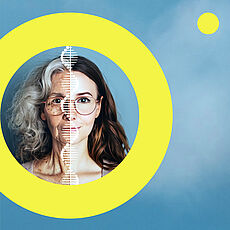 Porträt einer Frau mit Brille, das mittig durch eine DNA-Helix geteilt wird: links als ältere Frau mit grauem, lockigem Haar, rechts als junge Frau mit dunkelbraunem, lockigem Haar. Ein gelber Kreis umrahmt das Gesicht vor blauem Hintergrund.