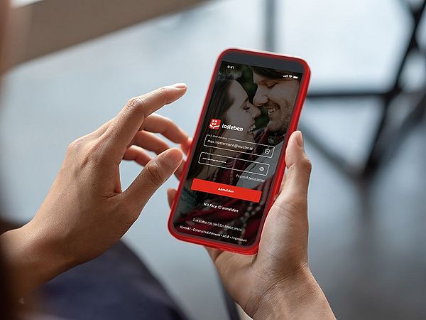 Ein Smartphone wird während der Anmeldung in der losleben-App in den Händen gehalten.