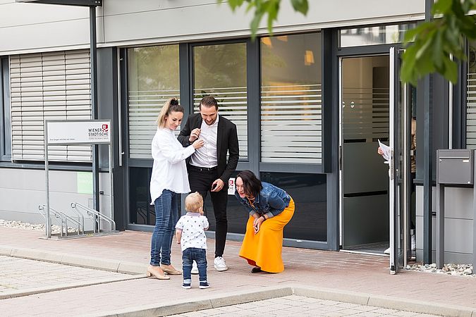 Mehrere Personen stehen vor einem Bürogebäude.