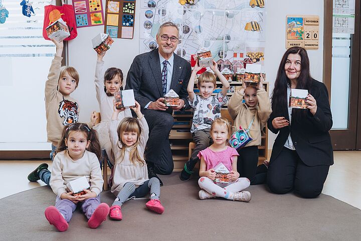Auf dem Bild sieht man 7 Kinder und 2 Erwachsene mit Adventkalendern