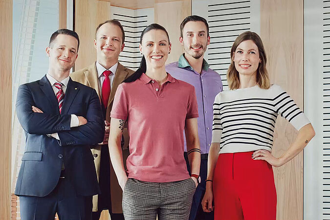 Mitarbeiterinnen und Mitarbeiter der Wiener Städtischen stehen zusammen und präsentieren das Unternehmen.