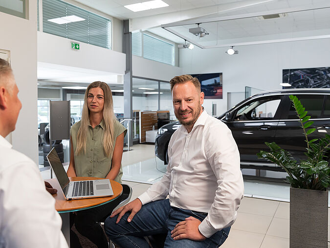 Mehrere Personen sitzen beisammen und unterhalten sich.