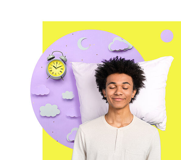 Ein strubbeliger junger Mann mit geschlossenen Augen steht lächelnd vor einem Kopfpolster und einem Wecker mit neongelbem Zifferblatt.