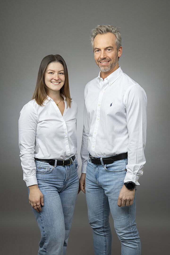 Eine Frau und ein Mann in Jeans und weißer Bluse bzw. weißem Hemd. 
